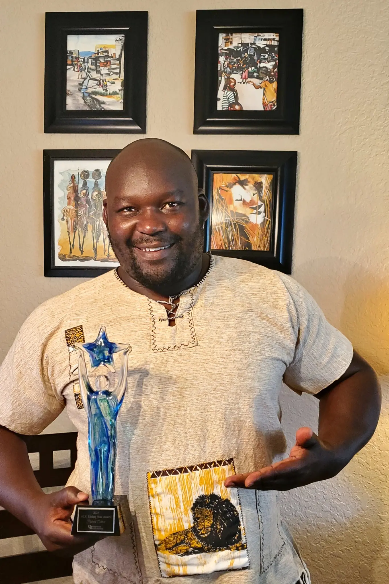 Patrick O. Odoyo holding the University of Evansville 2023 Martin Luther King Jr. Rising Star Service Award